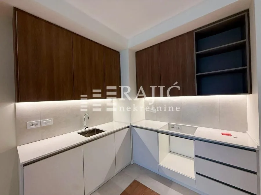 Modern kitchen with white lower cabinets, wooden upper cabinets, and integrated lighting.