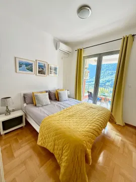 Svijetla spavaća soba sa bračnim krevetom, žutim detaljima i izlazom na terasu. - image 6