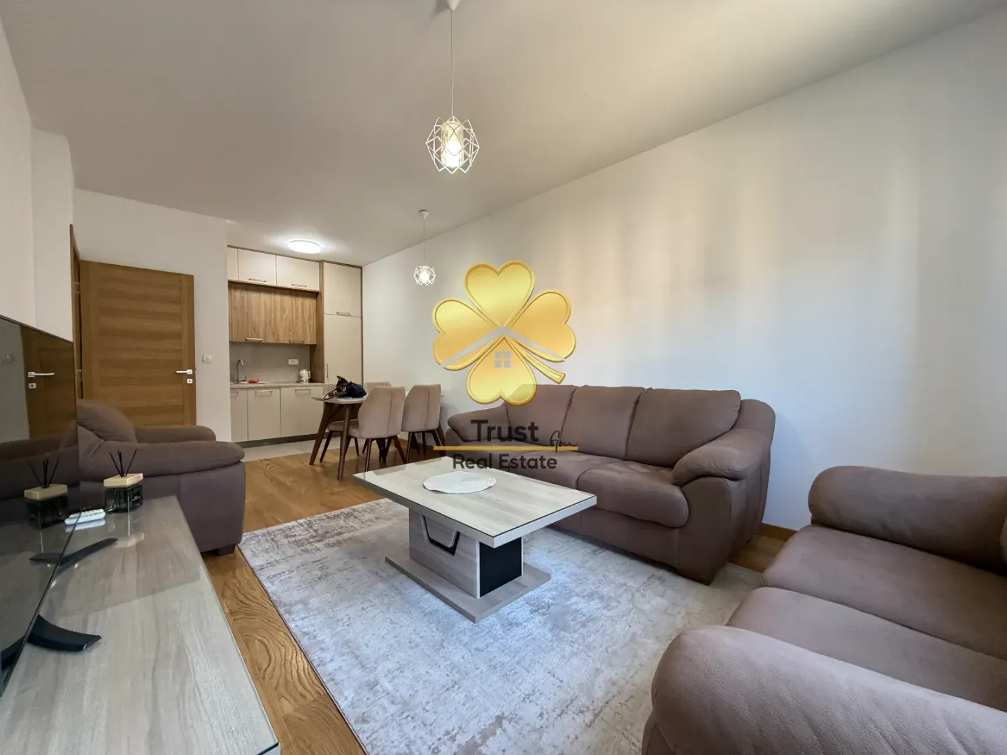 Spacious living room with seating set and a view of the kitchen.
