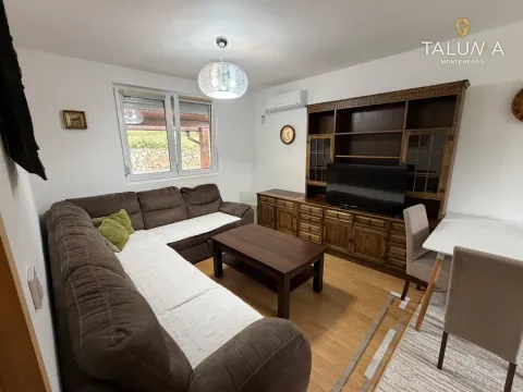 Living room with a sectional sofa, wooden furniture, and a dining area. - image 2