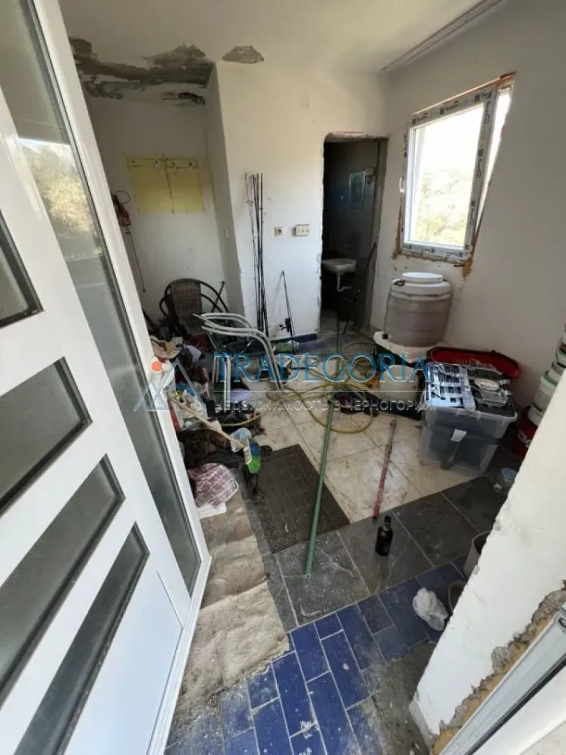 Prikaz prostorije u procesu renoviranja sa različitim materijalima i alatom.