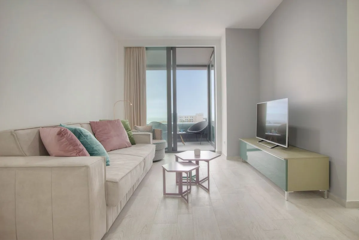 Living room with sofa, TV cabinet, and access to the terrace.