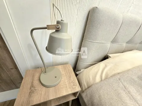 Detail of the bedroom with a bed, bedside table, and lamp. - image 8