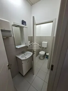 Small bathroom with a sink, mirror, and toilet in a separate section. - image 16