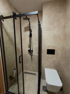 Modern bathroom equipped with a shower cabin and black fixtures. - image 16