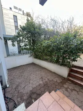 Paved courtyard with greenery next to the building. - image 14