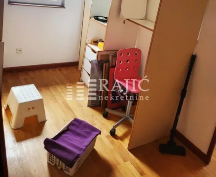 Manja soba sa drvenim podom, nameštajem i raznim predmetima. - image 9