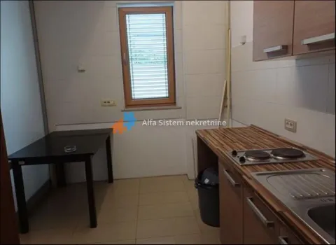 Small kitchen with a sink, built-in cooktop, and dining table. - image 13