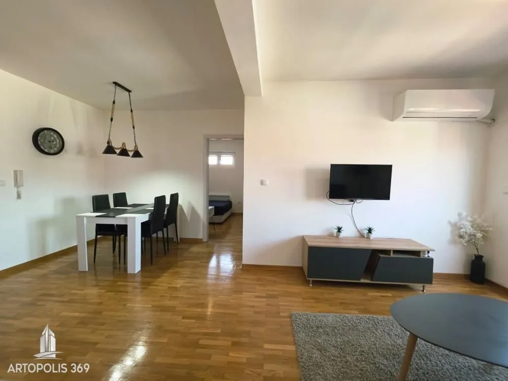 Spacious living room with a dining area and parquet flooring.