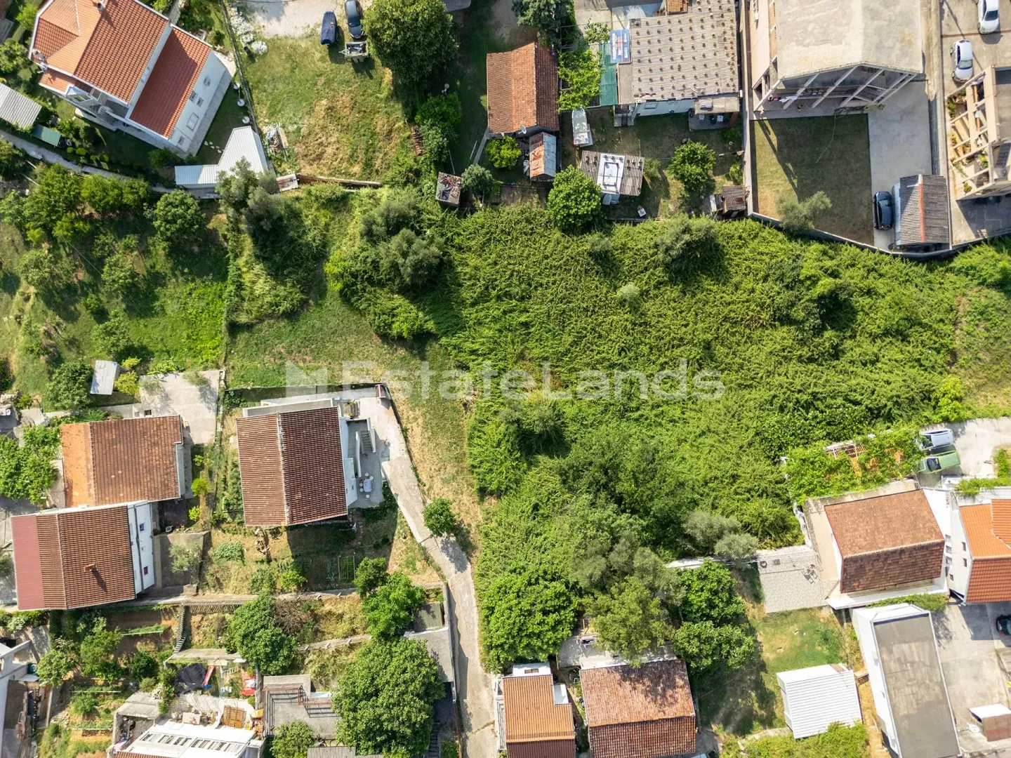 Pogled iz vazduha na plac sa okolnim objektima i zelenilom.