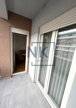 Pogled na popločanu terasu sa vratima i prozorom koji vode u stan. - image 9
