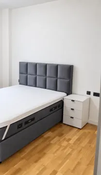 Uređena spavaća soba sa bračnim krevetom i noćnim stočićem. - image 4