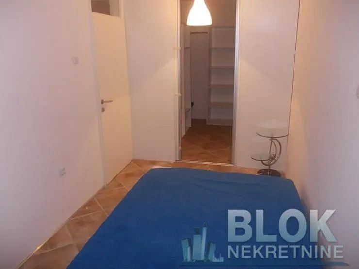 Smaller bedroom with a bed and a walk-in closet passageway.