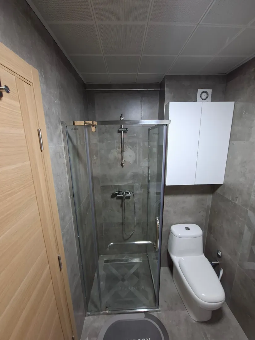 Moderno opremljeno kupatilo sa tuš kabinom i wc šoljom.