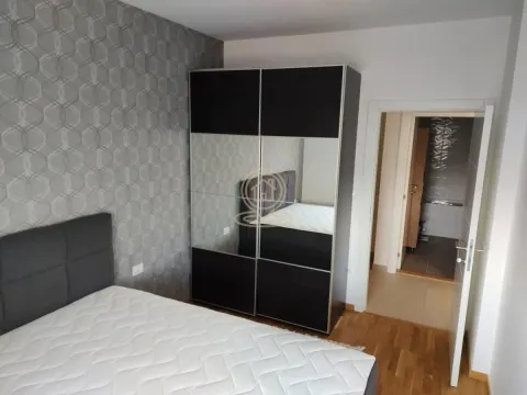 Nameštena spavaća soba sa bračnim krevetom i velikim ormarom sa ogledalom. - image 10