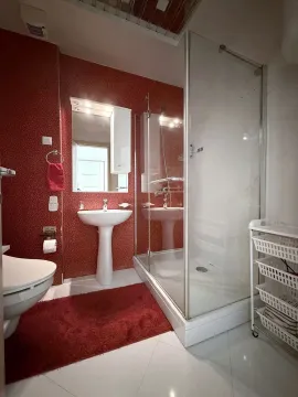 Modern bathroom with a shower cabin, sink, and toilet. - image 13