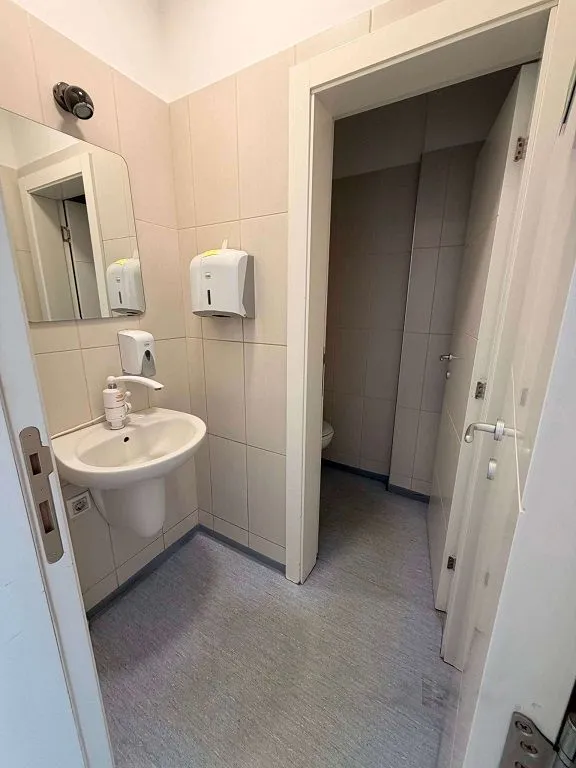 Smaller bathroom with a washbasin and wall tiles.