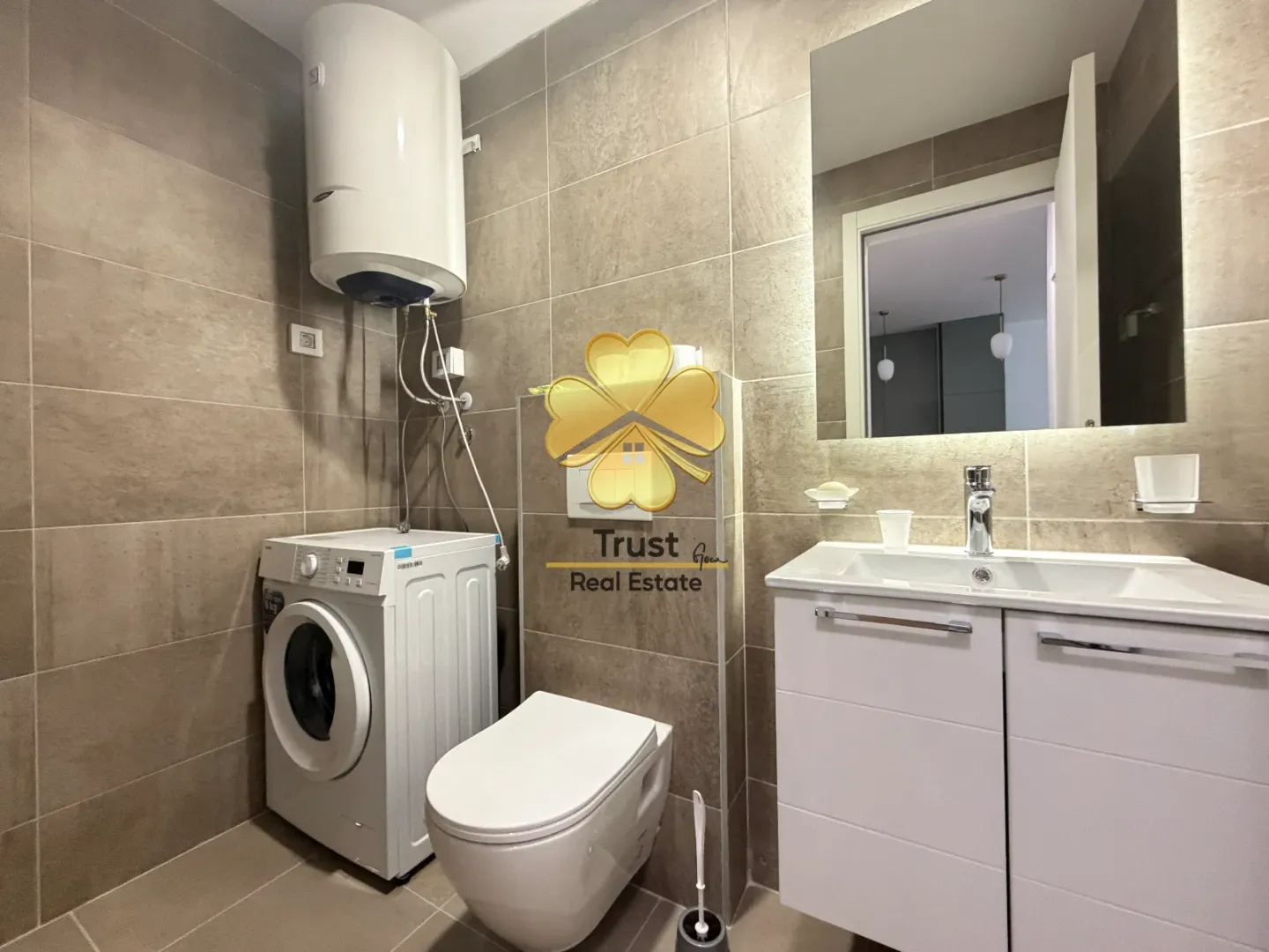 Modernly equipped bathroom with a shower, washing machine, and built-in units.