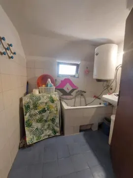 Manje kupatilo sa kadom, bojlerom i pločicama na zidovima i podu. - image 12