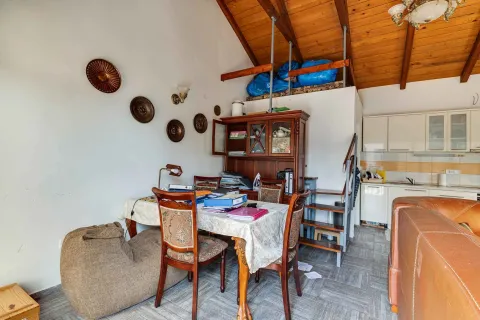 Dnevna soba sa trpezarijom, drvenim plafonom i kuhinjom u pozadini. - image 6