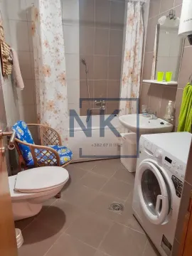 Bathroom equipped with sanitary ware, bathtub, and washing machine. - image 4