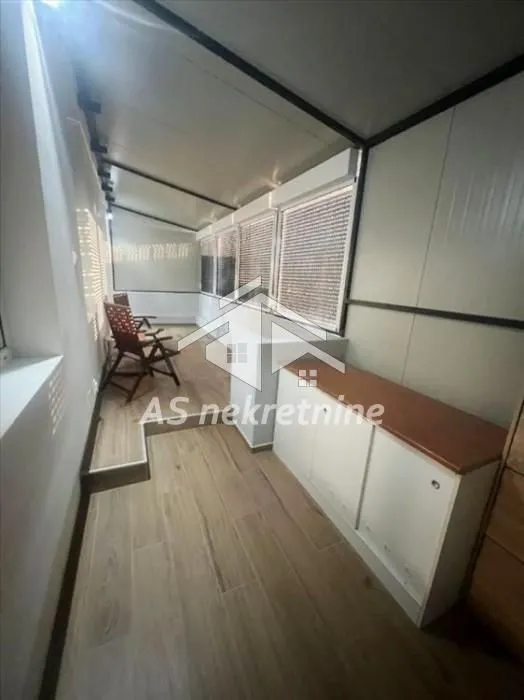 Glazed terrace with wooden flooring and a view.