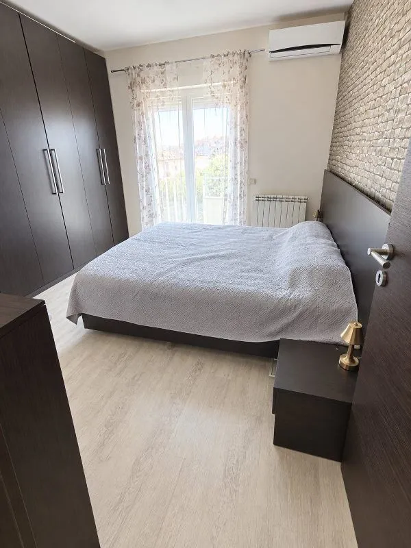 Spavaća soba sa bračnim krevetom, velikim garderoberom i izlazom na balkon.