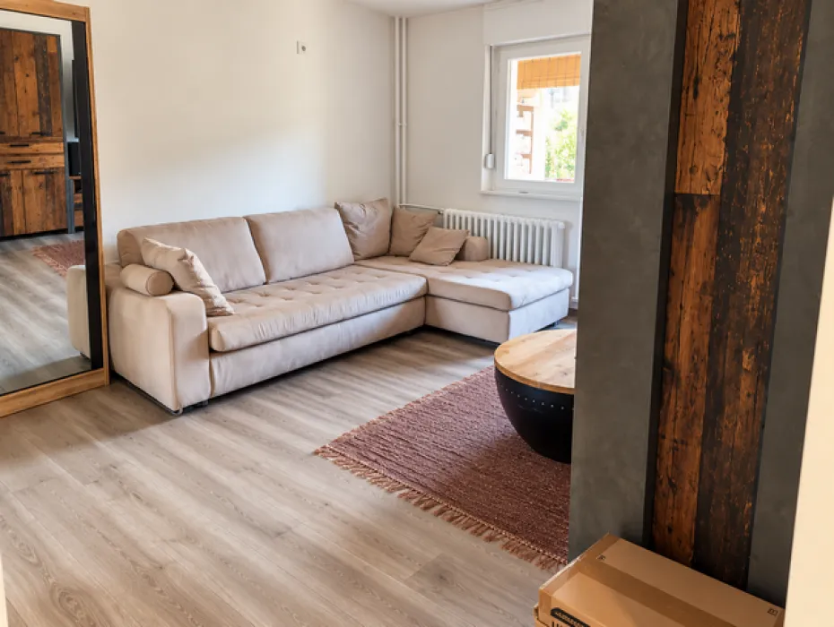 Living room with a sectional sofa, coffee table, and large mirror.