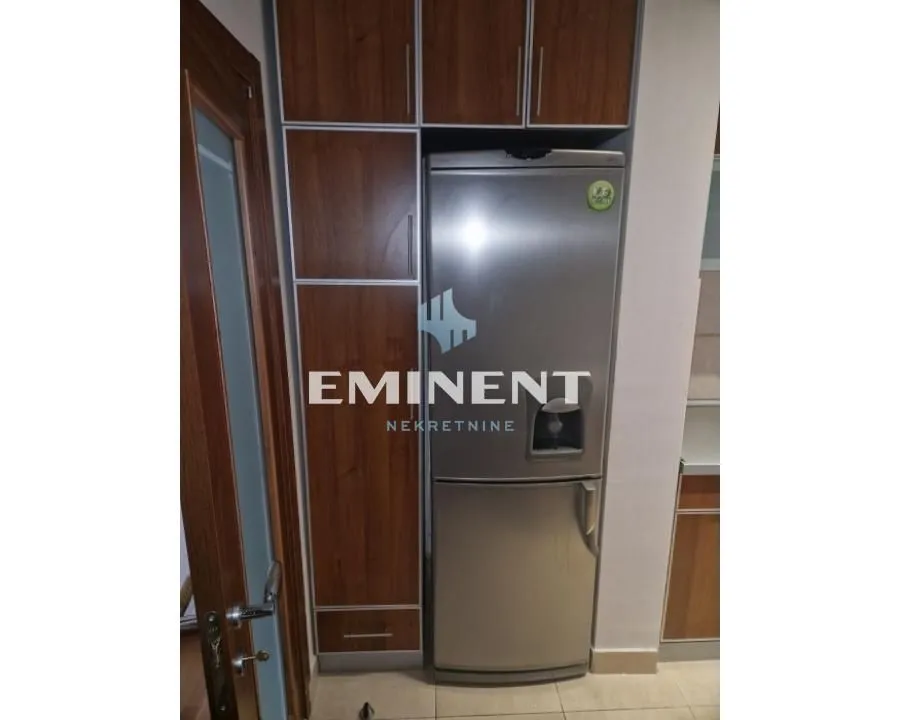 Kitchen with refrigerator and built-in kitchen cabinets.