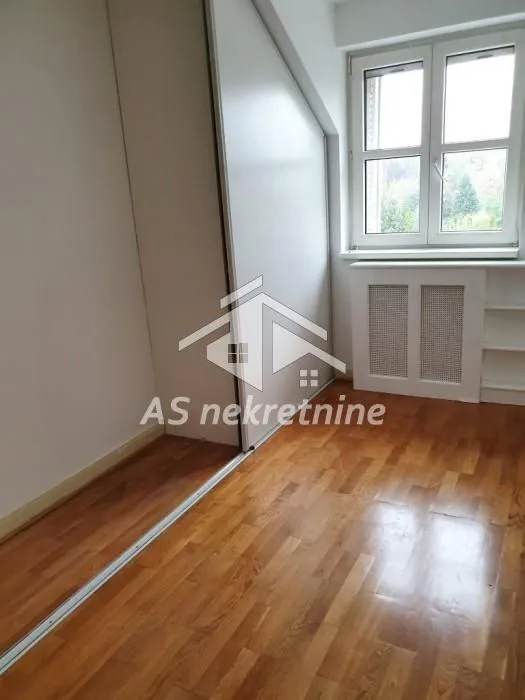 Smaller room with parquet flooring, built-in wardrobe, and a window.