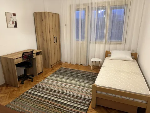 Jednostavno namještena spavaća soba sa jednim krevetom, radnim stolom i ormarom. - image 10