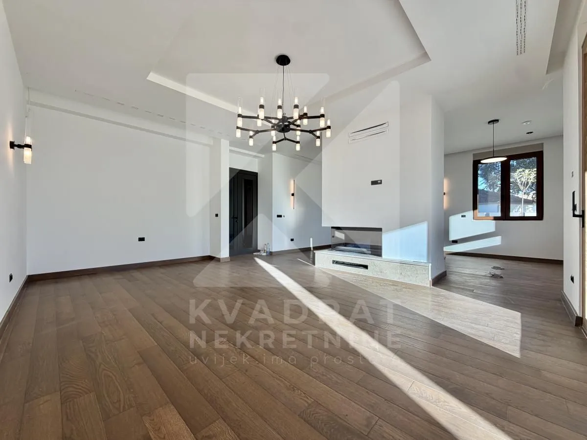 Spacious bright living room with hardwood floors and a built-in fireplace.
