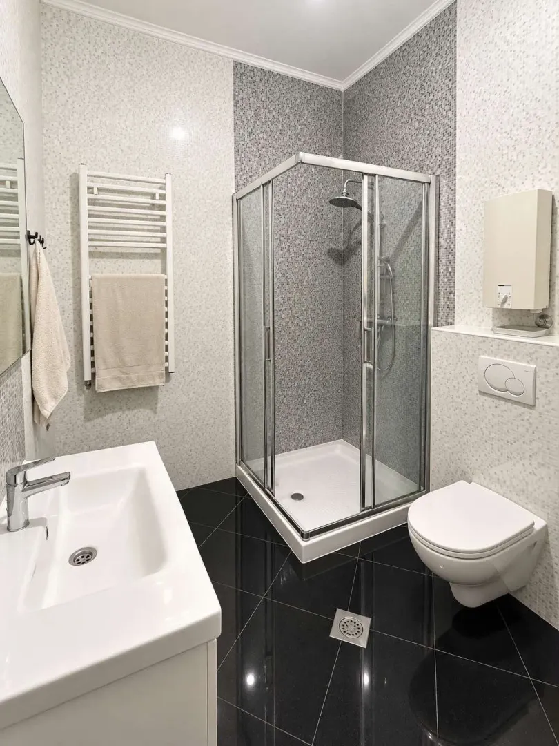 Moderno opremljeno kupatilo sa tuš kabinom, umivaonikom i wc šoljom.