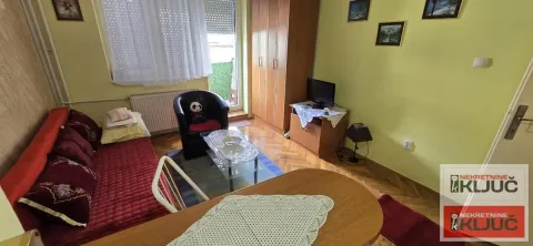Manja dnevna soba sa garniturom za sedenje, televizorom i izlazom na terasu. - image 3