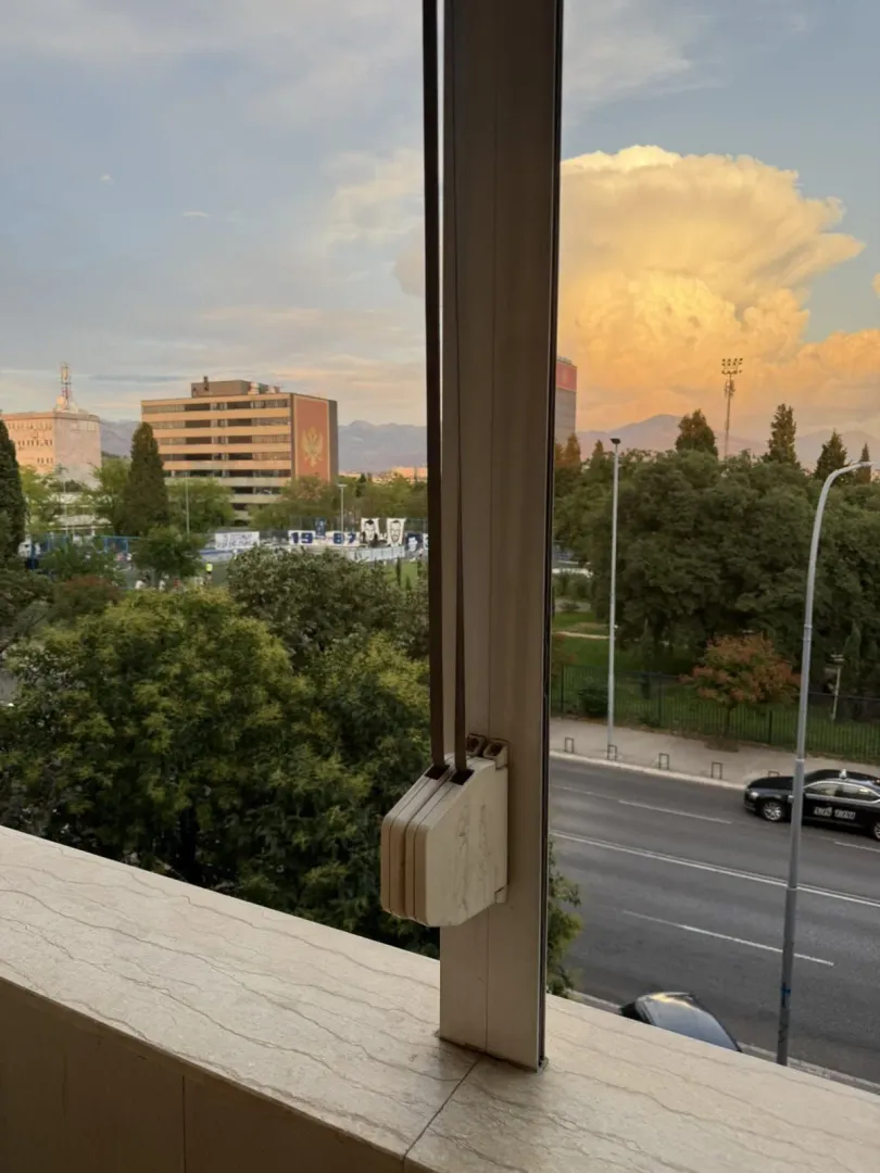 Pogled sa prozora na ulicu i gradsko okruženje.
