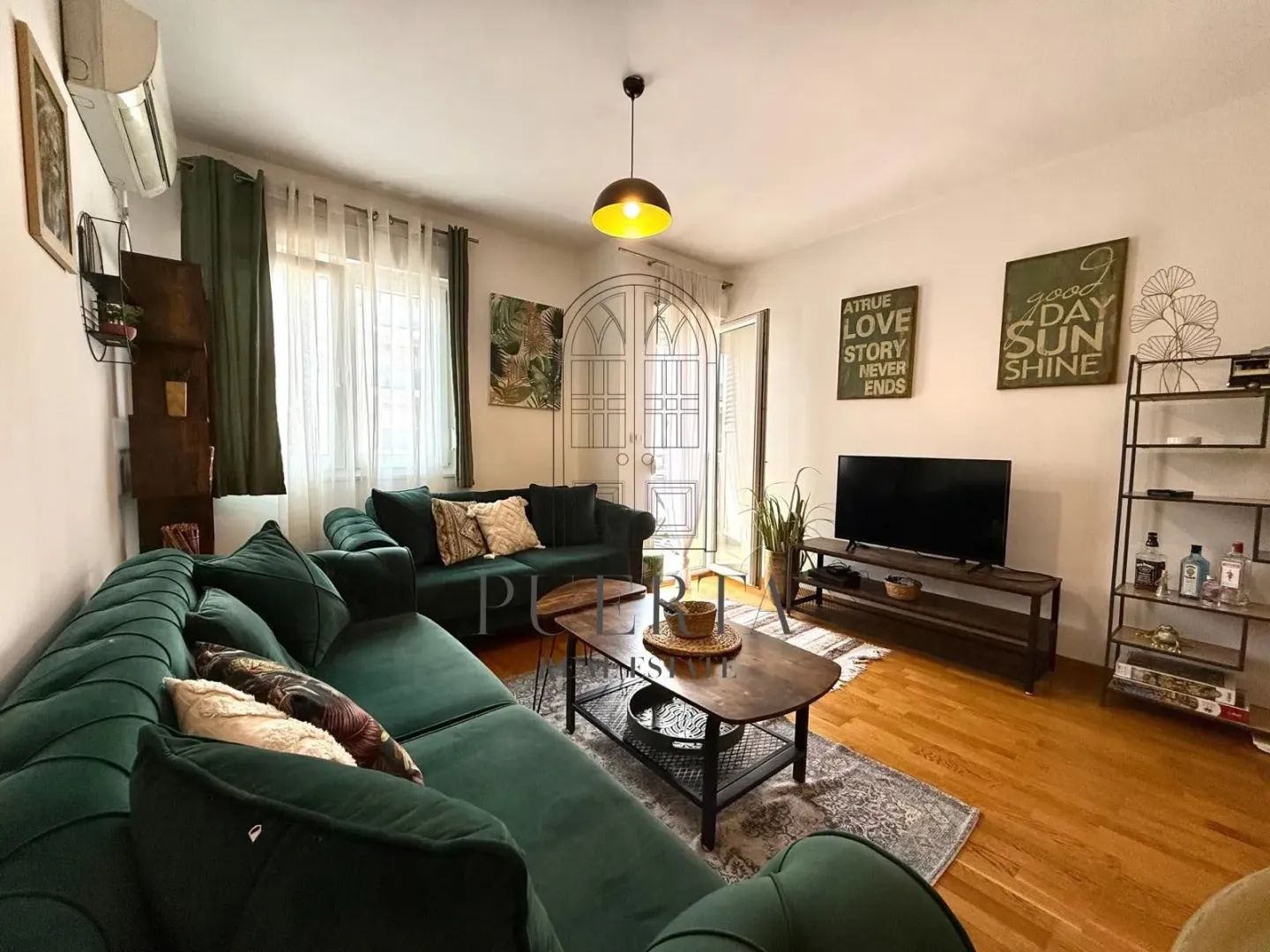 Living room with a green sofa set, wooden coffee table, and a TV.