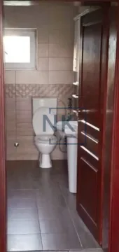 Small bathroom with a toilet, washbasin, and tiled walls. - image 11