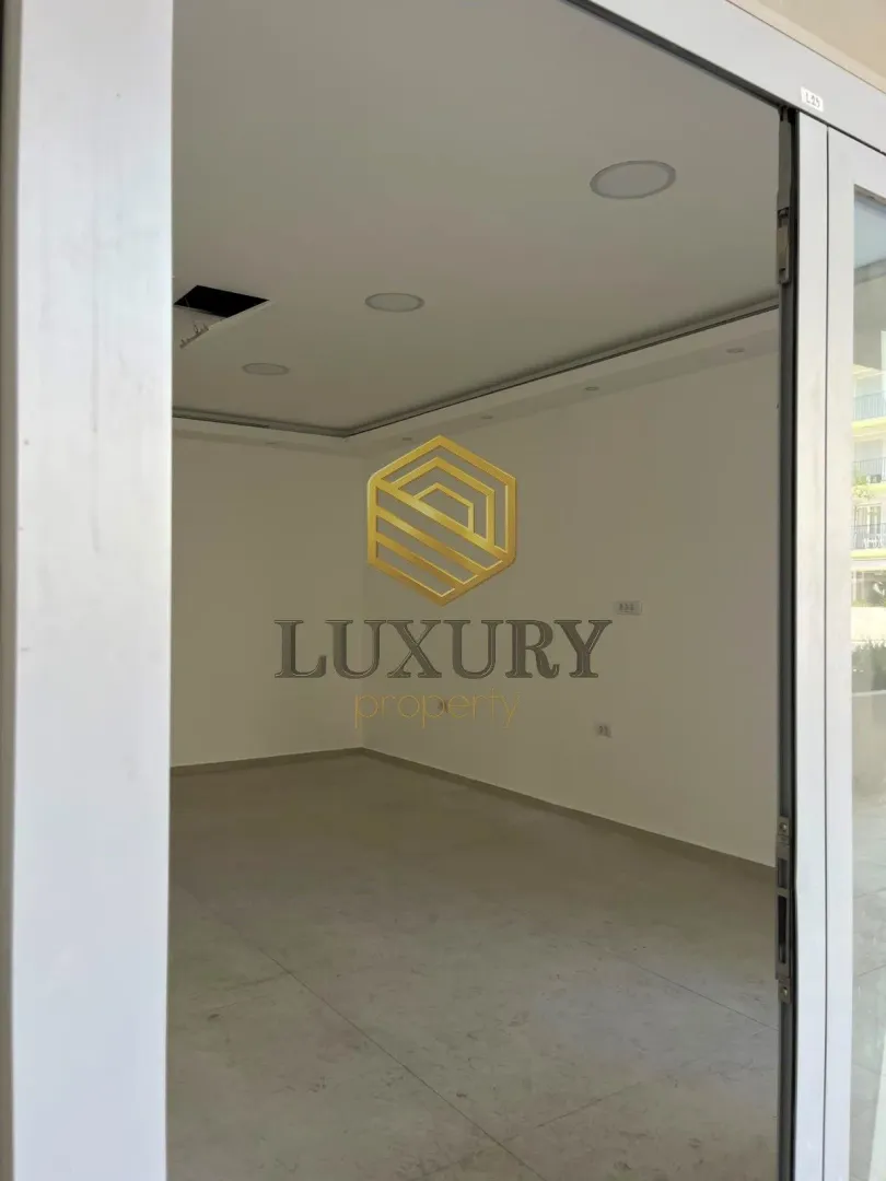 Empty unfurnished room with white walls and floor tiles.