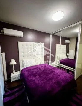 Spavaća soba sa bračnim krevetom, belim uzglavljem i velikim kliznim ormarom sa ogledalom. - image 10