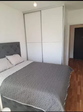 Svijetla spavaća soba sa bračnim krevetom i velikim bijelim plakarem. - image 5