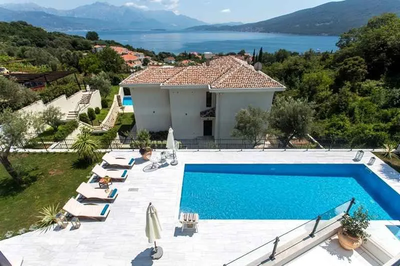 Pogled odozgo na bazen, dvorište i kuću sa pogledom na more.