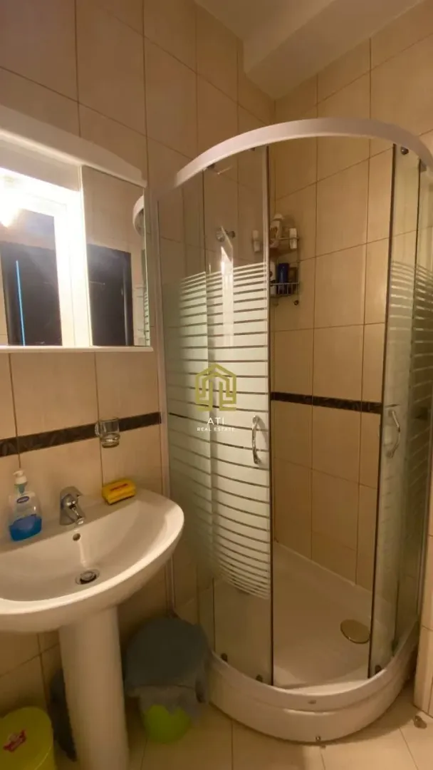 Manje kupatilo sa umivaonikom i tuš kabinom.