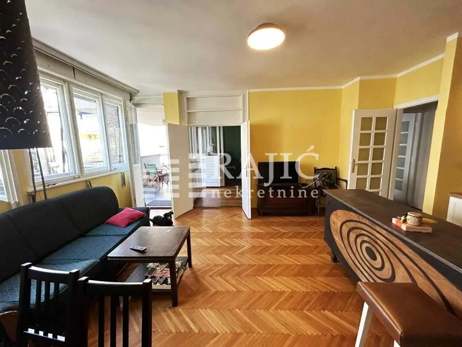 Living room with a sofa, dining table and access to the terrace.