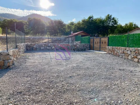 Fenced yard with gravel surface and stone walls. - image 9