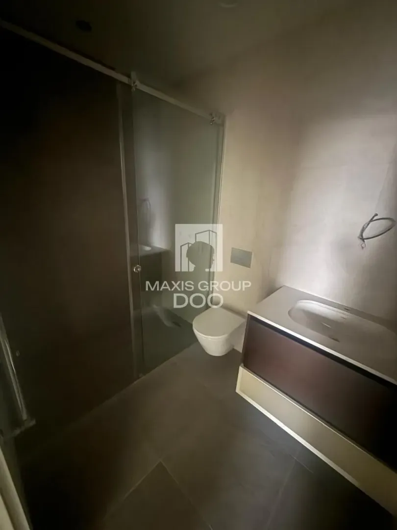 Modern bathroom with walk-in shower, vanity unit, and toilet.