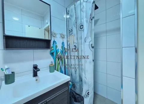 Small bathroom with a sink, mirror, and shower cabin. - image 9