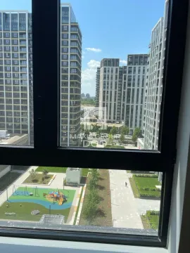 View from the window overlooking surrounding buildings and a courtyard with a playground. - image 11