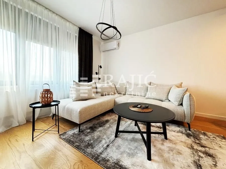 Bright living room with a corner sofa and a rug.