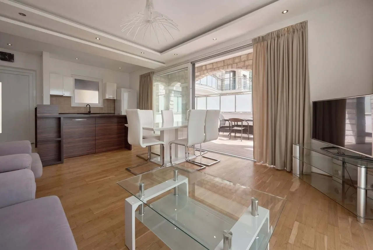 Spacious living room connected to the dining area and kitchen, with access to the terrace.
