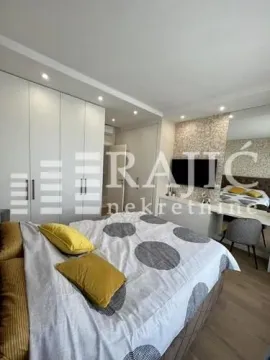 Modern bedroom with a large double bed, built-in wardrobes, and a television. - image 10
